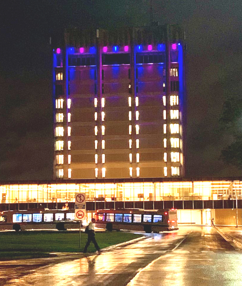 A wide shot of the Brock University Tower lit purple and blue