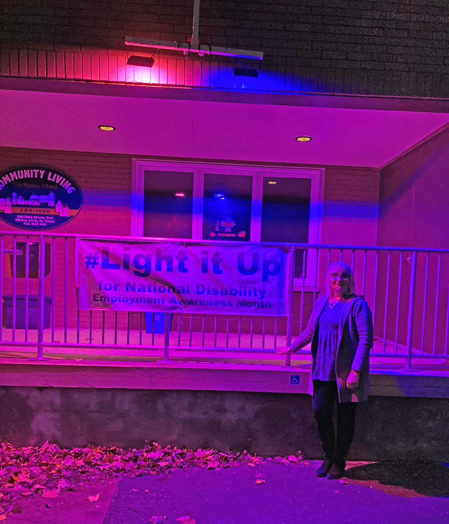 Front entrance deck of Community Living St. Marys glowing under purple and blue lighting from roof lights