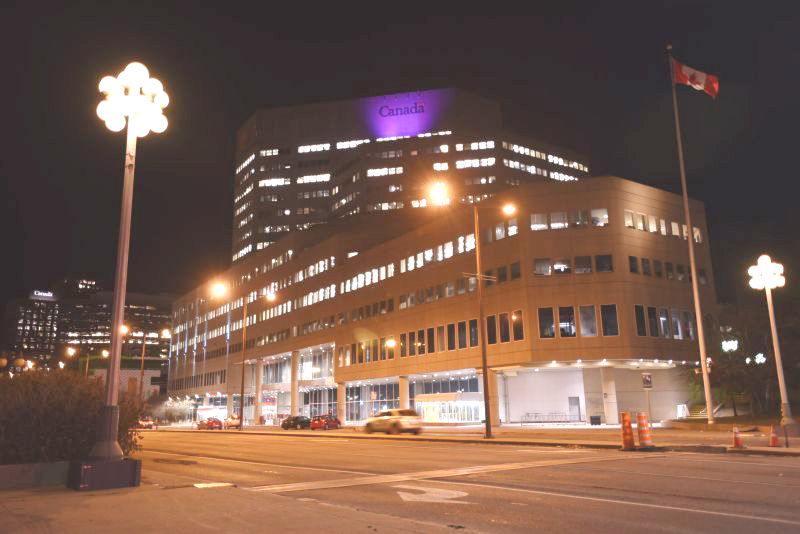 The "Canada" sign on the top of the Place du Portage 4 building lit with purple lighting