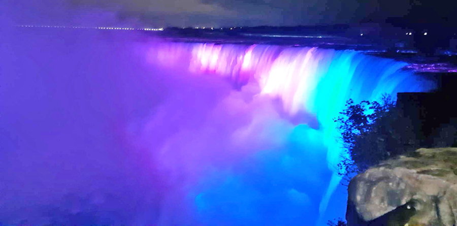The Horseshoe Falls and the mist glowing purple and blue