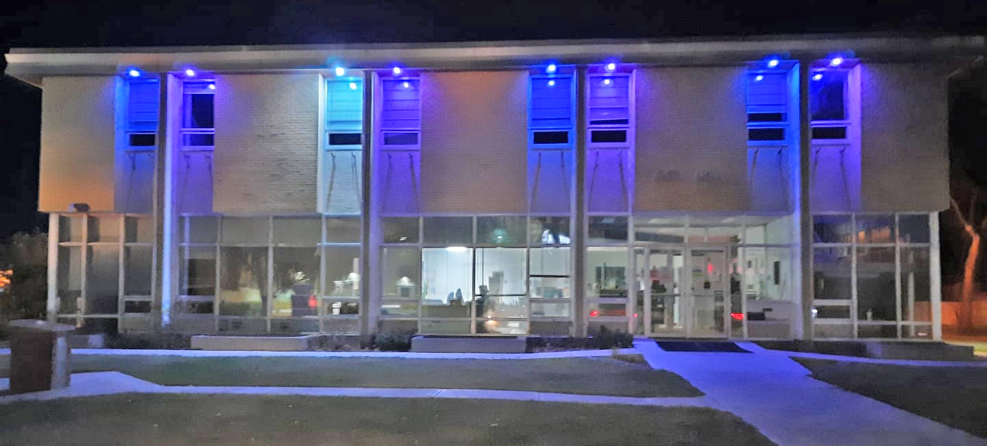 Roof lighting illuminates the windows of City Hall in Humboldt, Saskatchewan, purple and blue.