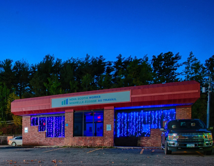 Windows at the Nova Scotia Works Employment Centre in Antigonish, Nova Scotia, lit purple and blue