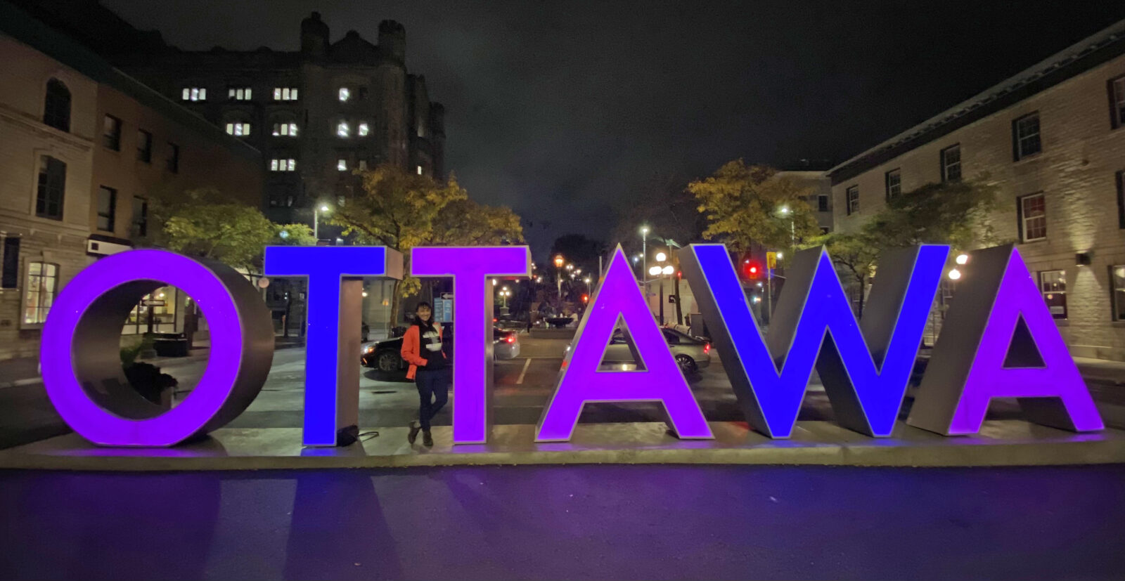 The Ottawa sign in Byward Market lit purple and blue.